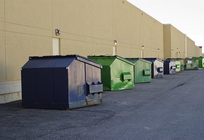 a group of dumpsters lined up along the street ready for use in a large-scale construction project in Camden, DE